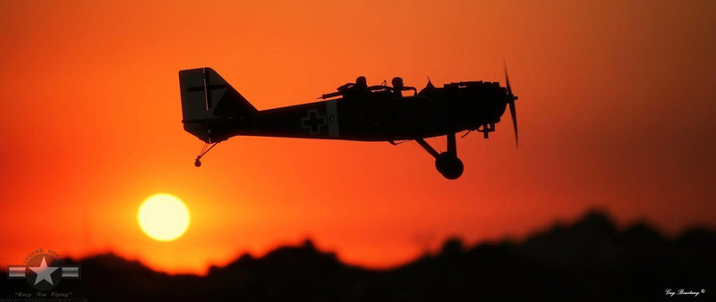 side view of JUNKERS CL1 G-BUYU 15cc flying in front of a sunset